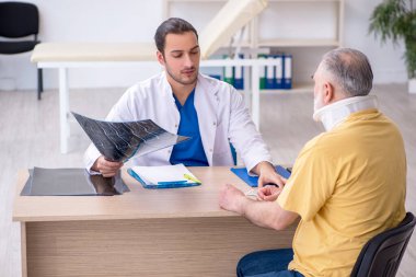 Yaşlı boyun yaralanması genç erkek doktor radyolojisti ziyaret ediyor.