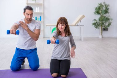 Kişisel koçla spor egzersizleri yapan genç bir kadın.