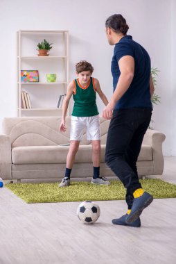 Baba ve oğul içeride spor yapıyor.