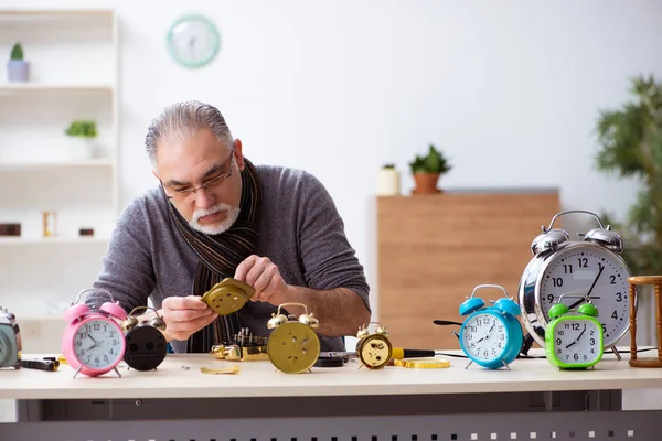 Alter Uhrmacher arbeitet in der Werkstatt — Stockfoto