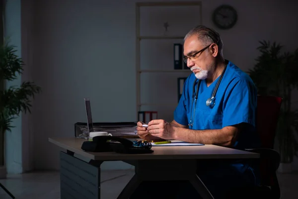 Geceleri hastanede yaşlı bir erkek doktor. — Stok fotoğraf