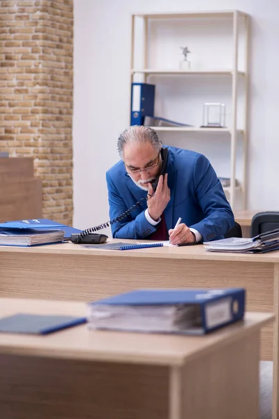 Oude mannelijke baas werknemer werken in het kantoor — Stockfoto