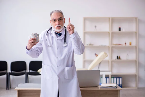 Velho médico do sexo masculino trabalhando na clínica — Fotografia de Stock