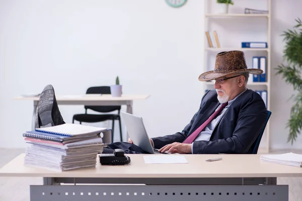 Vtipný starý šéf v kovbojském klobouku v kanceláři — Stock fotografie