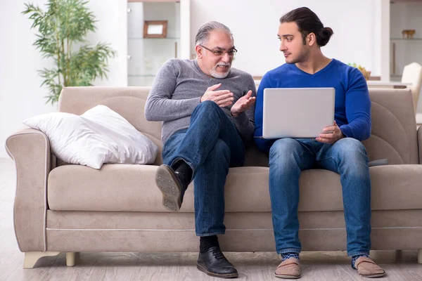Ayah dan anak duduk di sofa dengan komputer — Stok Foto