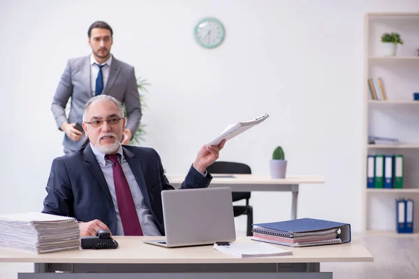 Old boss and his young assistant working in the office — Stock Photo, Image