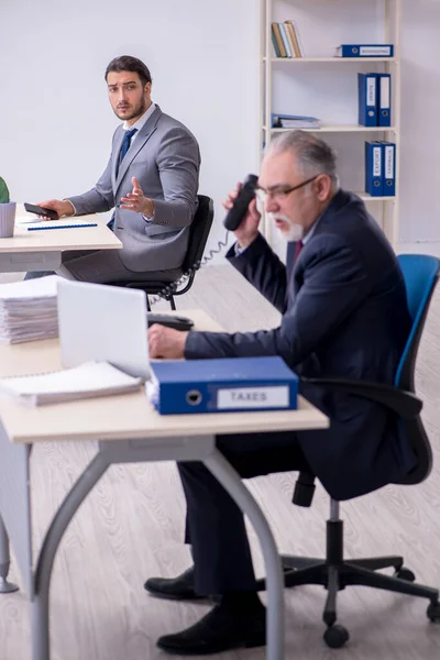 El viejo jefe y su joven asistente trabajando en la oficina — Foto de Stock