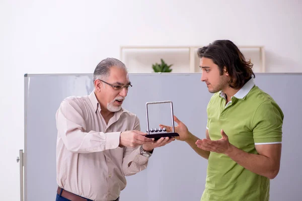 Yaşlı profesör fizikçi ve genç öğrenci sınıfta. — Stok fotoğraf