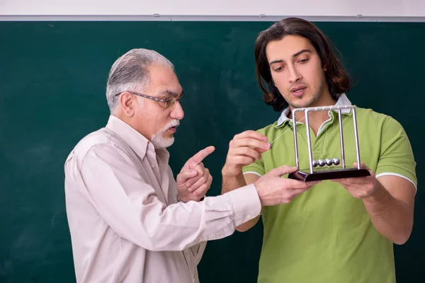 Oude hoogleraar natuurkunde en jonge student in de klas — Stockfoto