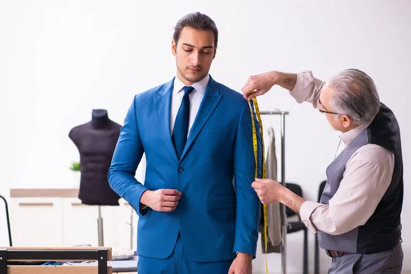 Jovem empresário visitando velho alfaiate masculino — Fotografia de Stock