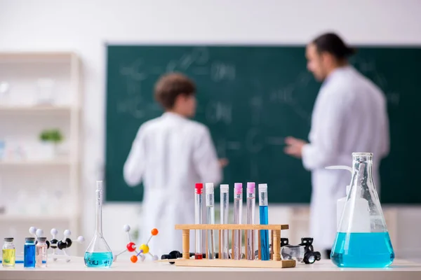 Jovem professor de química e estudante em sala de aula — Fotografia de Stock