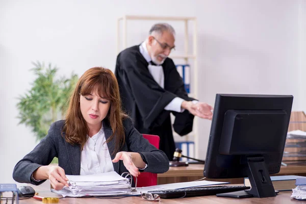 Oude mannelijke rechter en zijn jonge secretaresse op kantoor — Stockfoto