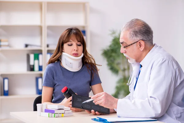 Giovane donna dopo l'incidente visitare il vecchio medico — Foto Stock