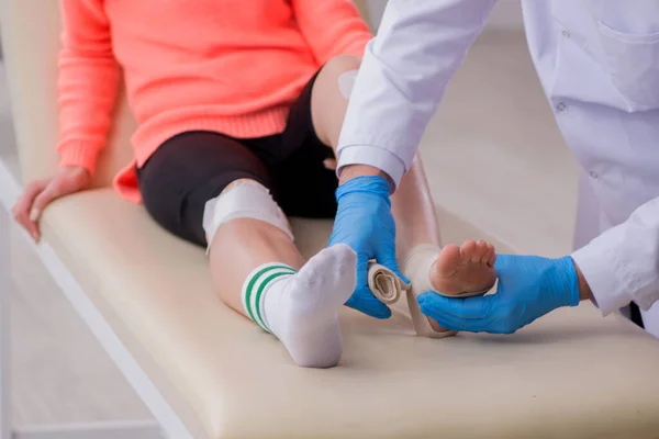Νεαρή τραυματισμένη στο πόδι γυναίκα που επισκέπτεται γιατρό τραυματολόγο — Φωτογραφία Αρχείου