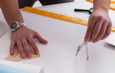 Erkek mühendis çizimler ve planlar üzerinde çalışıyor.