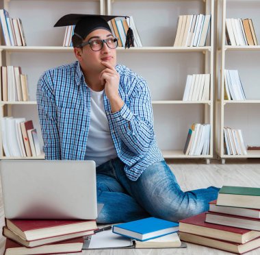 Genç öğrenci kitaplarla çalışıyor.