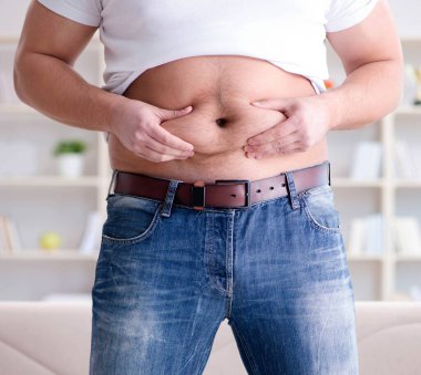 Diyet konseptinde fazladan ağırlık çeken adam.