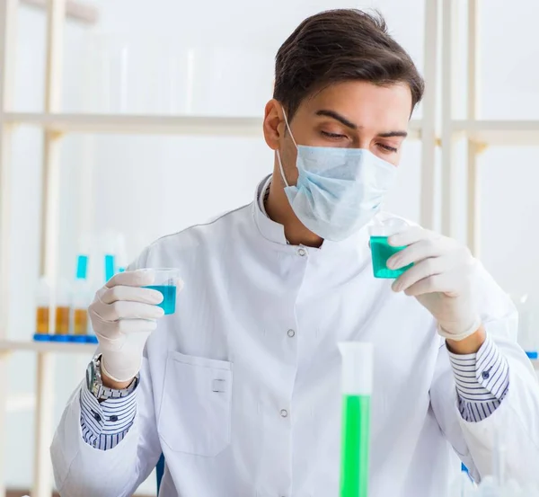 Giovane studente di chimica che lavora in laboratorio sui prodotti chimici — Foto Stock