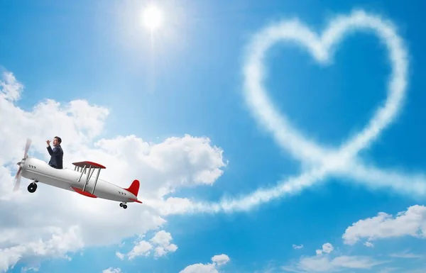 Man flyger flygplan och gör hjärtformen — Stockfoto
