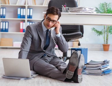 İş adamı ofiste çalışıyor ve oturuyor.