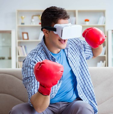 Sanal gerçeklik gözlüğü takan adam boks oyunu oynuyor.