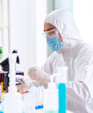 Laboratuvarda kimyasallar üzerinde çalışan genç bir kimyager.