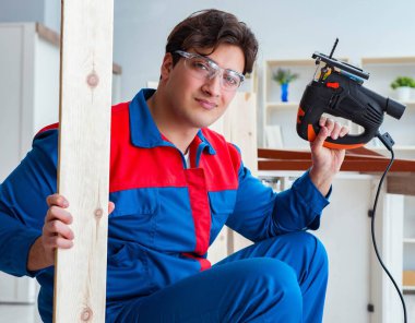 Genç marangoz ahşap kalaslarla çalışıyor.