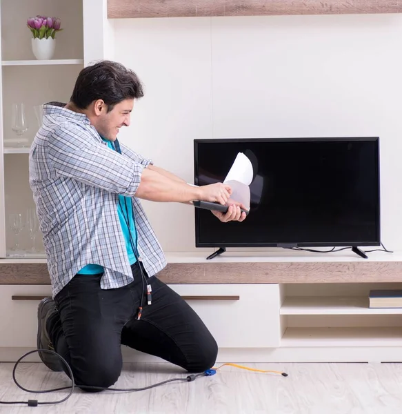 Man trying to fix broken tv