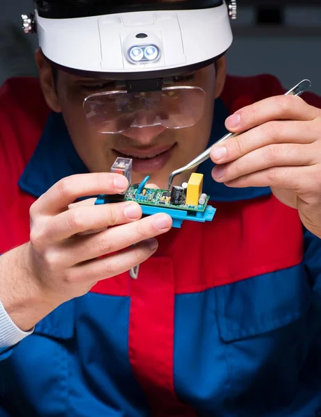 Computer specialist repairing PC late at night