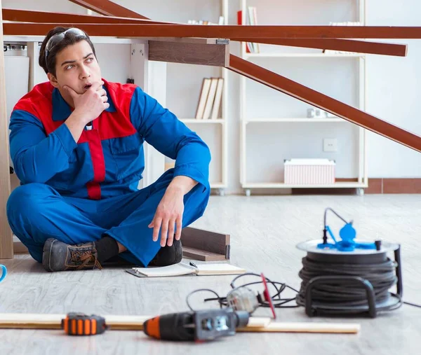 İnşaatta defter planlama yapan genç bir marangoz.