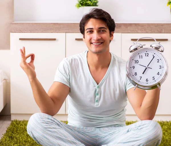 Ung man gör yoga i sovrum i time management koncept — Stockfoto