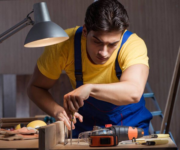 Worker working in repair workshop in woodworking concept