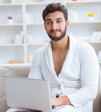 Evde dizüstü bilgisayarla çalışan serbest çalışan genç adam.