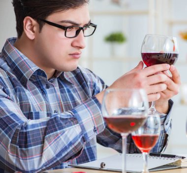 Profesyonel şarap garsonu kırmızı şarap tadıyor.