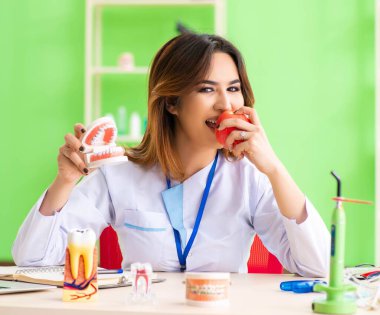 Diş implantı üzerinde çalışan kadın dişçi.