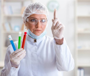 Laboratuvarda sanal düğmeye basan kadın kimyager.