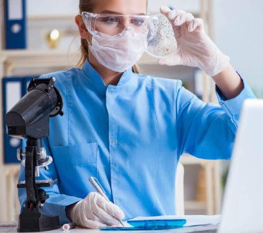 Bir laboratuarda deney yapan kadın bir bilim adamı.