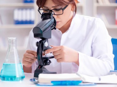 Bir laboratuarda deney yapan kadın bir bilim adamı.