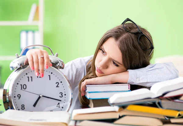 Joven estudiante preparándose para los exámenes con muchos libros a tiempo — Foto de Stock