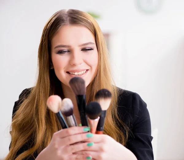 Mujer joven aplicando maquillaje preparándose para la fiesta —  Fotos de Stock