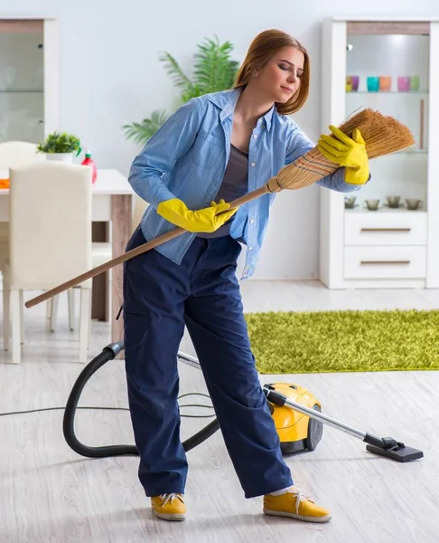 Junge Frau putzt Fußboden zu Hause und erledigt Hausarbeiten — Stockfoto