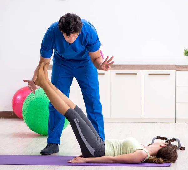 Instrutor de fitness ajudando desportista durante o exercício — Fotografia de Stock