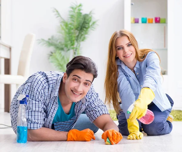 Jovem família limpando a casa — Fotografia de Stock