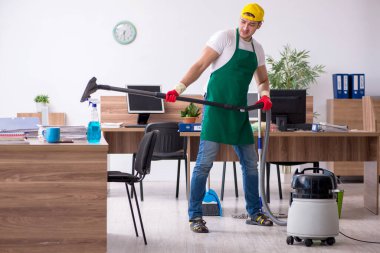 Genç müteahhit ofisi temizliyor.