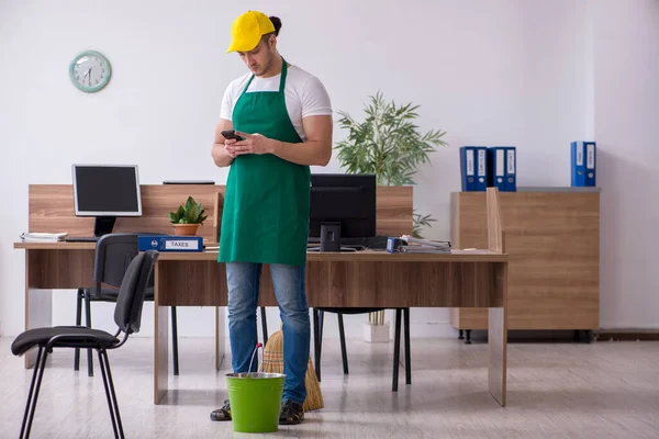 Joven contratista masculino limpiando la oficina — Foto de Stock