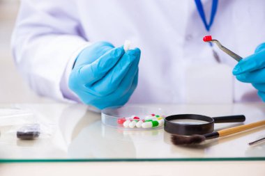 Kanıt için laboratuvarda çalışan yaşlı bir erkek kriminolog.