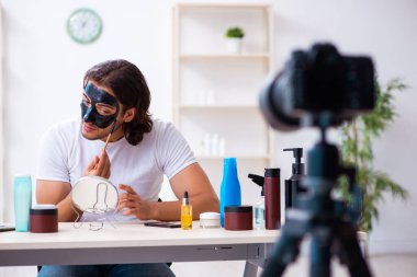 Genç erkek kozmetikçi blogu için video kaydediyor.