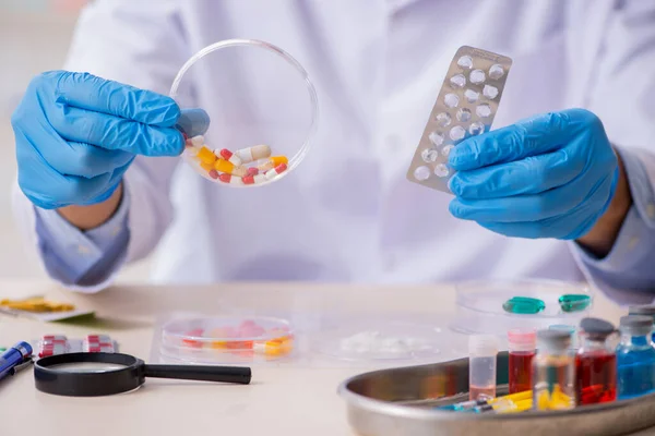 Joven asistente de laboratorio masculino en concepto de síntesis de fármacos —  Fotos de Stock