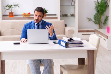 Evden kendini izole etme konseptiyle çalışan genç bir erkek işçi.