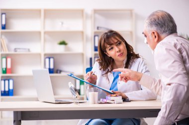 Yaşlı adam estetik ameliyat için genç bayan doktoru ziyaret ediyor.